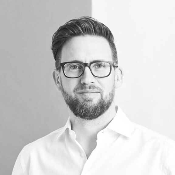 Mann mit Bart und Brille lächelt in die Kamera